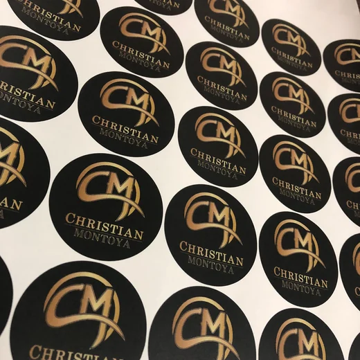 Proyecto real de Creador Gráfico: Plancha de stickers circulares con acabado elegante en dorado y negro.